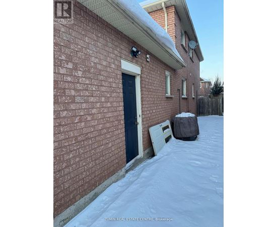 A red brick house with a black door and a white door.