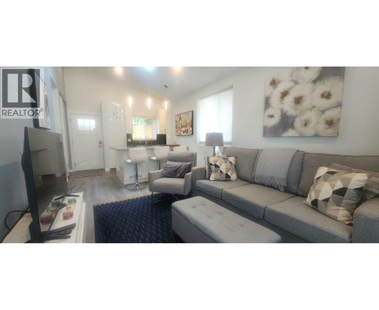 A living room with a grey couch and a television.