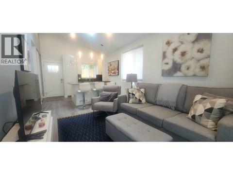 A living room with a grey couch and a television.