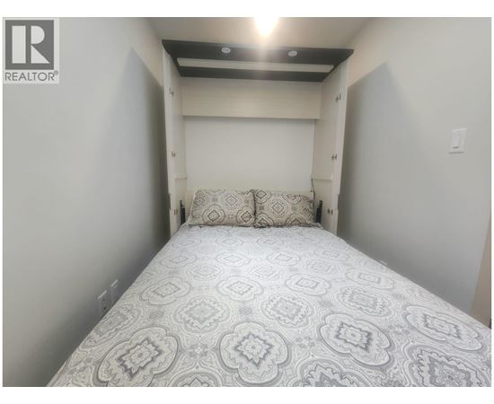A bedroom with a bed and a pillow.
