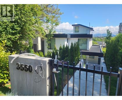 A modern house with a white fence and a mailbox with the number 3550 on it.