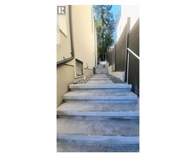 A set of concrete stairs leads up a narrow alley between two buildings.