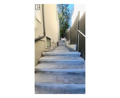 A set of concrete stairs leads up a narrow alley between two buildings.