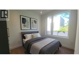 A bedroom with a large bed and two framed pictures on the wall.