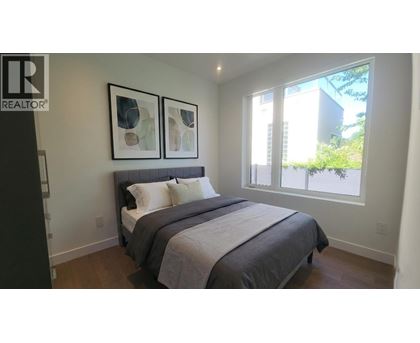 A bedroom with a large bed and two framed pictures on the wall.
