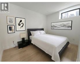 A bedroom with a large bed and a mountain painting on the wall.