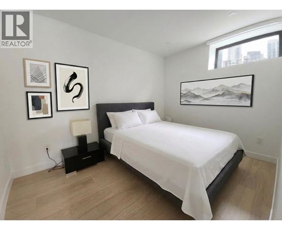 A bedroom with a large bed and a mountain painting on the wall.