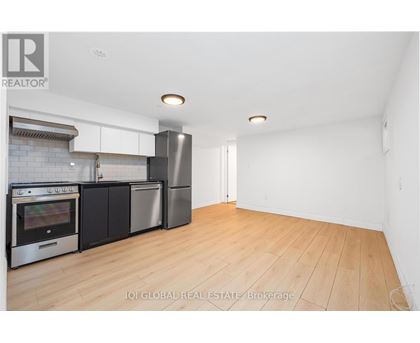 A kitchen with a refrigerator, oven, and microwave.