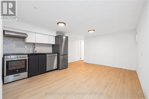A kitchen with a refrigerator, oven, and microwave.