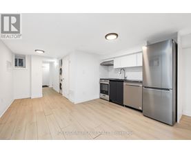 A kitchen with a refrigerator, oven, and sink.