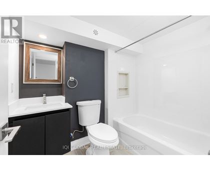 A bathroom with a white toilet, sink, and bathtub.