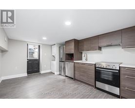 A modern kitchen with dark wood cabinets and stainless steel appliances.
