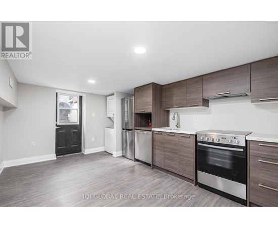 A modern kitchen with dark wood cabinets and stainless steel appliances.