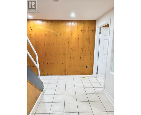 A room with a wooden wall and a white door.