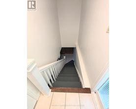 A staircase with a white railing and wooden handrail.