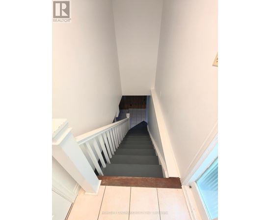 A staircase with a white railing and wooden handrail.