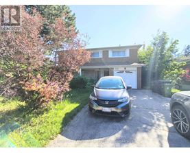 A Honda car is parked in front of a house.