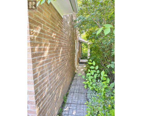 A brick wall with a pathway leading to a door.