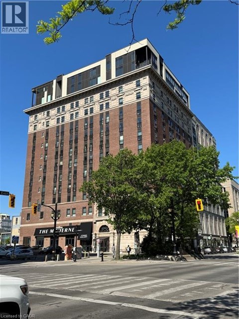 A tall building with a sign that says "The M" in front of it.