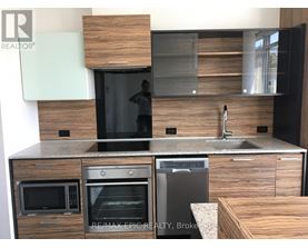 A modern kitchen with a sink, microwave, and oven.