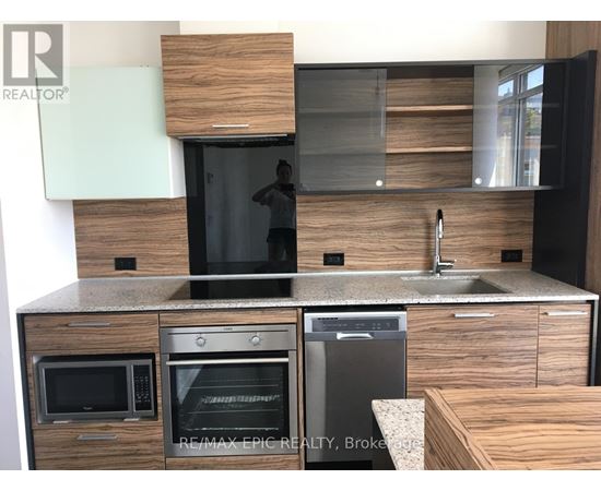 A modern kitchen with a sink, microwave, and oven.
