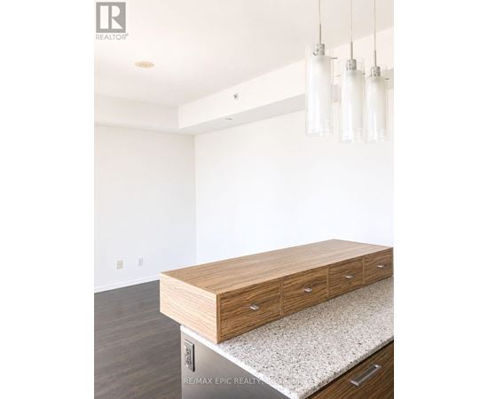 A wooden drawer is on a countertop in a white room.
