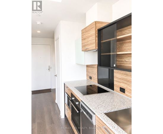 A modern kitchen with a stainless steel sink and wooden cabinets.