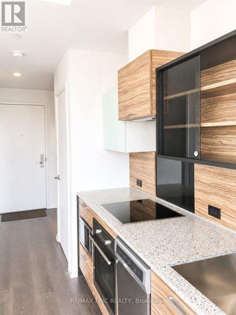 A modern kitchen with a stainless steel sink and wooden cabinets.