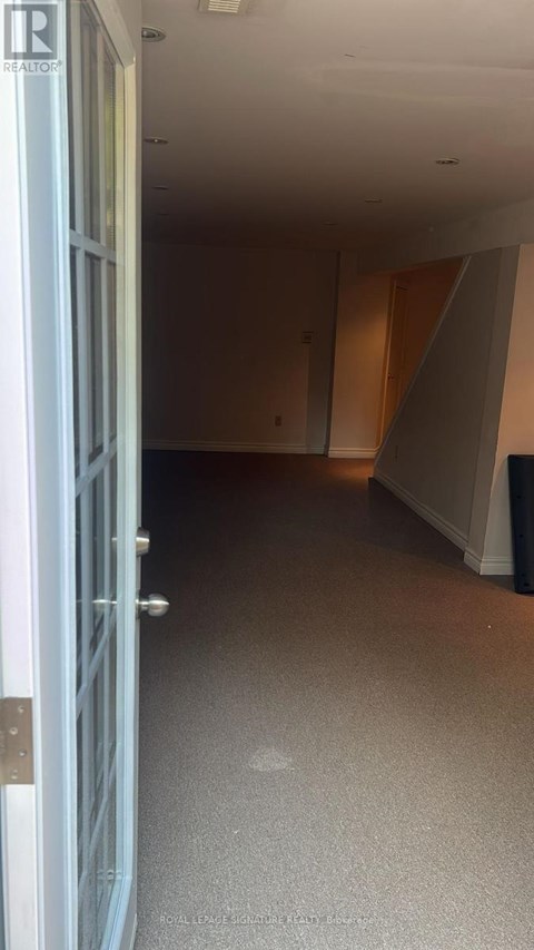 A room with a white door and carpeted floor.