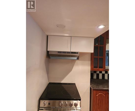 A kitchen with a black stove top and white cabinets.