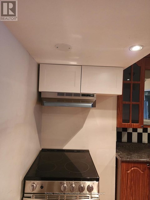 A kitchen with a black stove top and white cabinets.