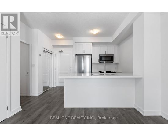 A white kitchen with a refrigerator and microwave.