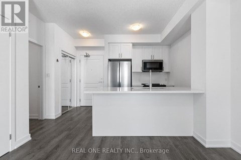 A white kitchen with a refrigerator and microwave.