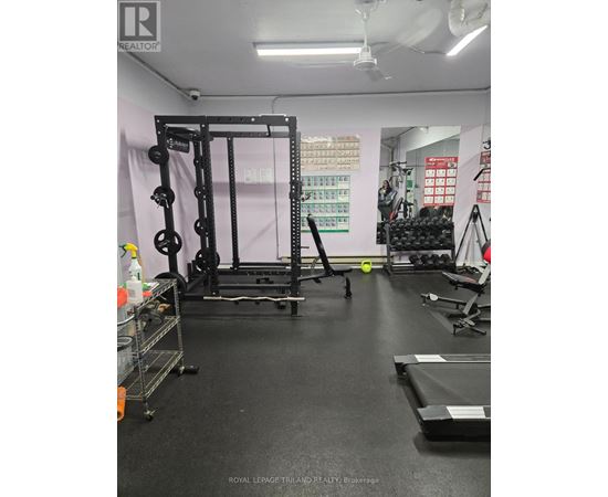 A gym with a squat rack, weight bench, and other equipment.