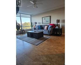 A living room with a couch, a coffee table, and a ceiling fan.