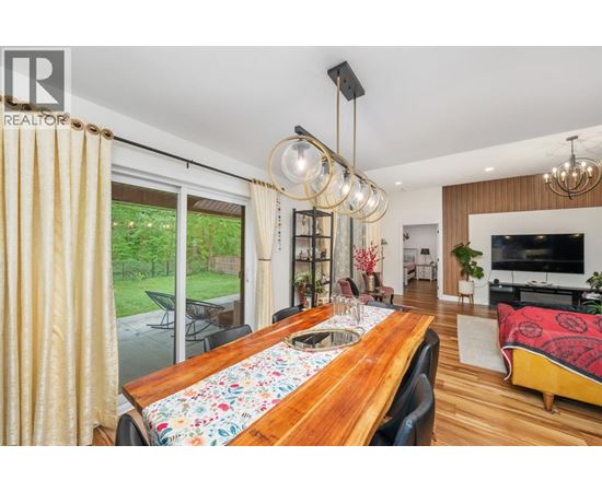A modern dining room with a wooden table and chairs.
