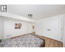A bedroom with a bed and a white door.