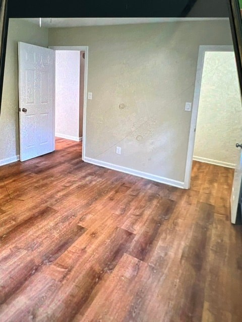 A room with wooden flooring and a white door.