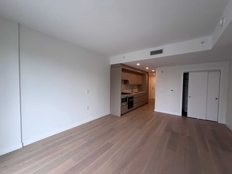 A room with wooden flooring and white walls.