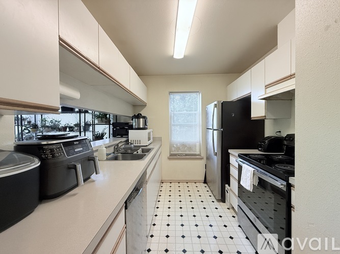 A kitchen with black and white tiles on the floor.