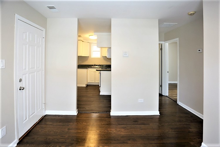 A kitchen with white cabinets and a white door.