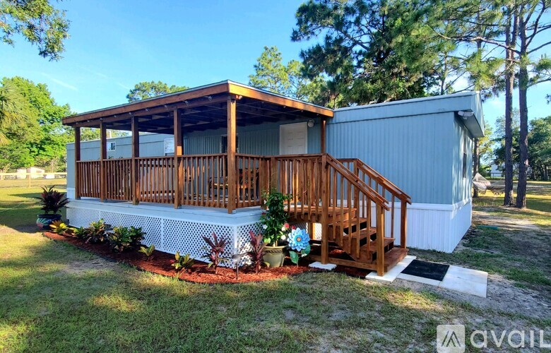 A house with a wooden deck and a metal roof is for sale.