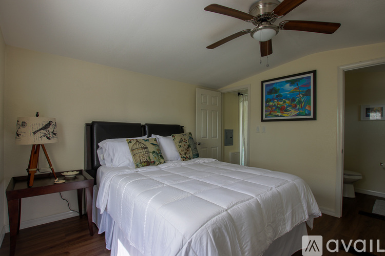 A bedroom with a large bed and a ceiling fan.