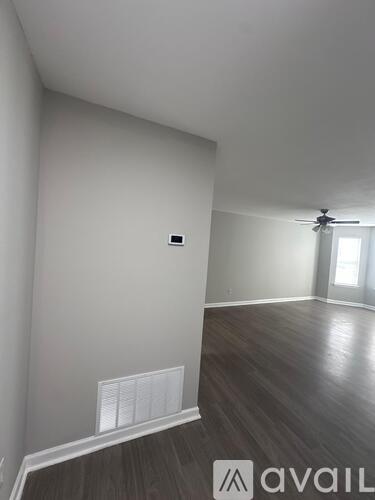 A room with a ceiling fan and a window with blinds.