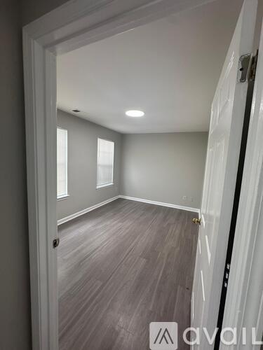 A room with wooden flooring and white walls.