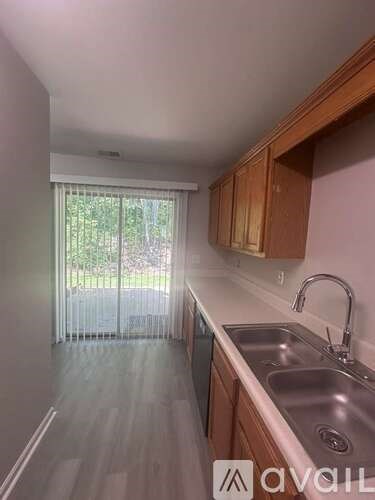 A kitchen with wooden cabinets and a stainless steel sink.