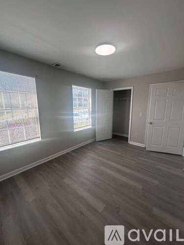 A room with a white door and a window with blinds.