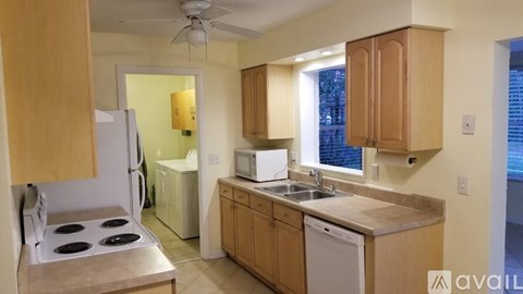 A kitchen with wooden cabinets and a white fridge.