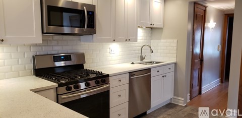 A kitchen with white cabinets and a stainless steel oven.