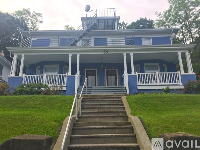 A blue house with a white porch and stairs leading to the front door.